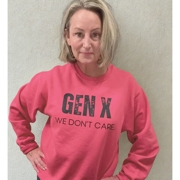 Person wearing a pink sweatshirt with 'GEN X WE DON'T CARE' text against a plain background