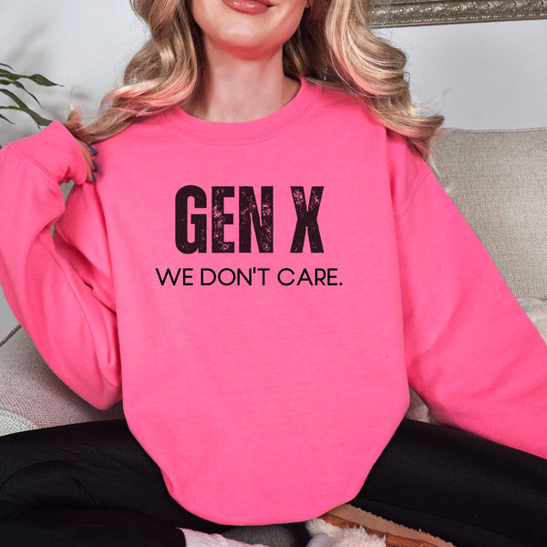 Woman sitting in bright pink sweatshirt with "GEN X: WE DON'T CARE" in black font.