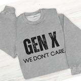 Gray sweatshirt with 'GEN X WE DON'T CARE' text on a light wooden surface