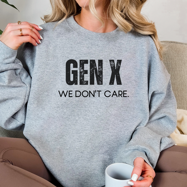 Person wearing a gray sweatshirt with 'GEN X WE DON'T CARE' text, holding a mug.
