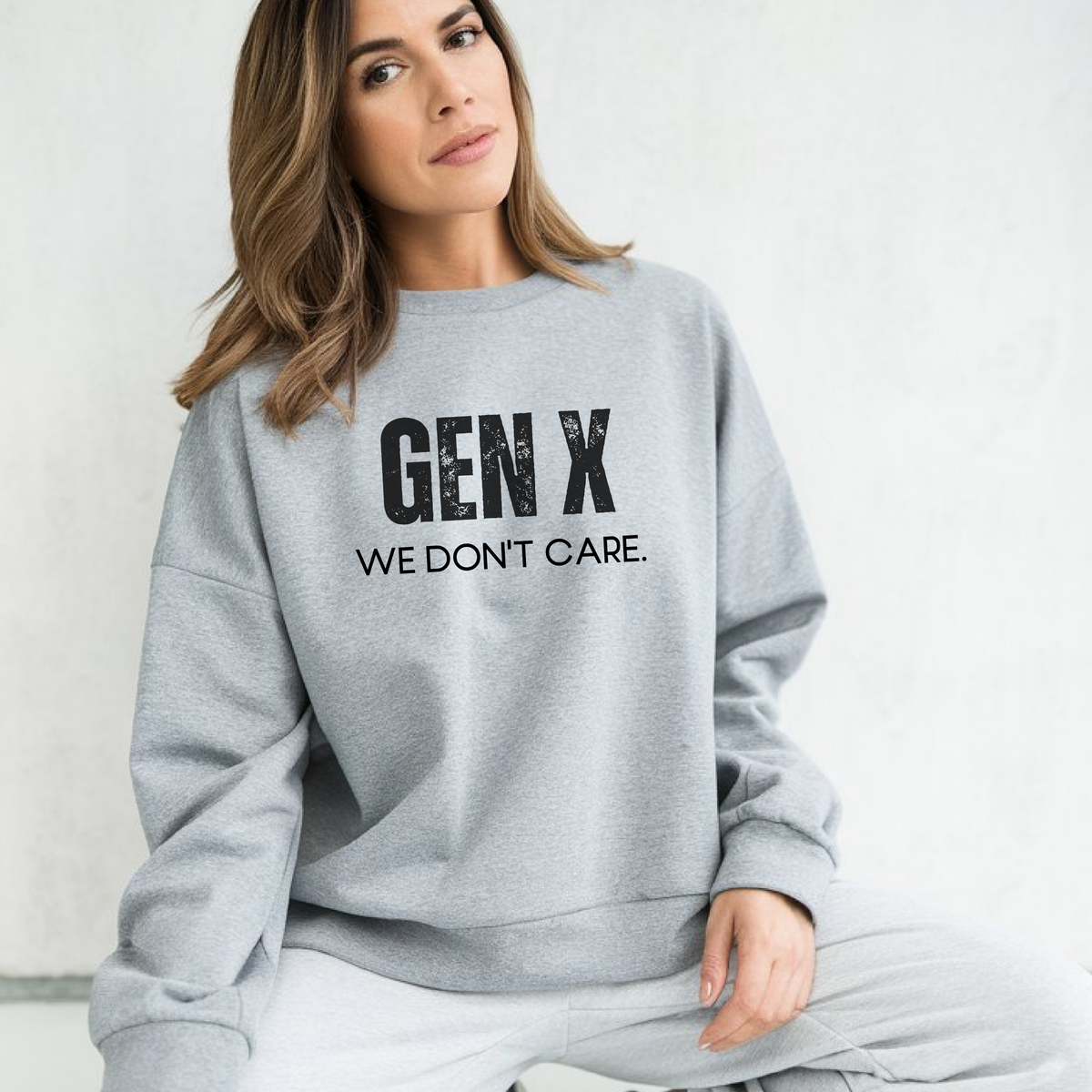 Woman wearing a gray sweatshirt with 'GEN X WE DON'T CARE' text on a white background