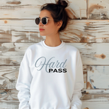 Woman standing against a wall with a white sweatshirt on that says, 