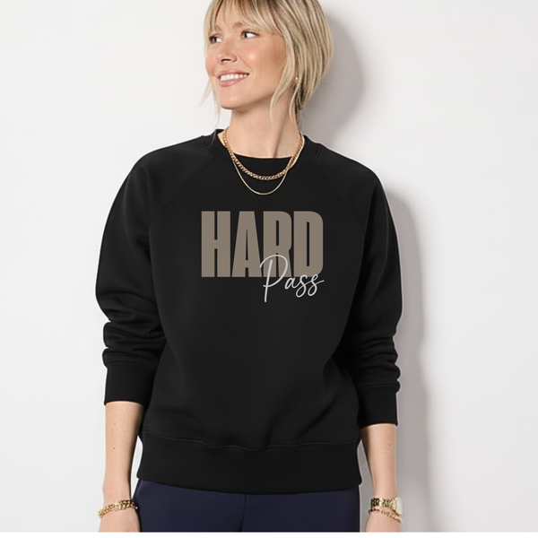 A woman standing in a black sweatshirt with the words "Hard Pass:" written in khaki and white.