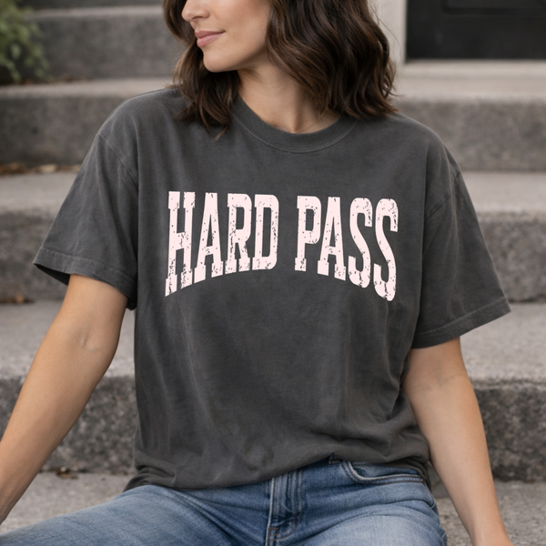 A woman standing in a distressed black tee shirt with the words "Hard Pass" written across the front in pink font.
