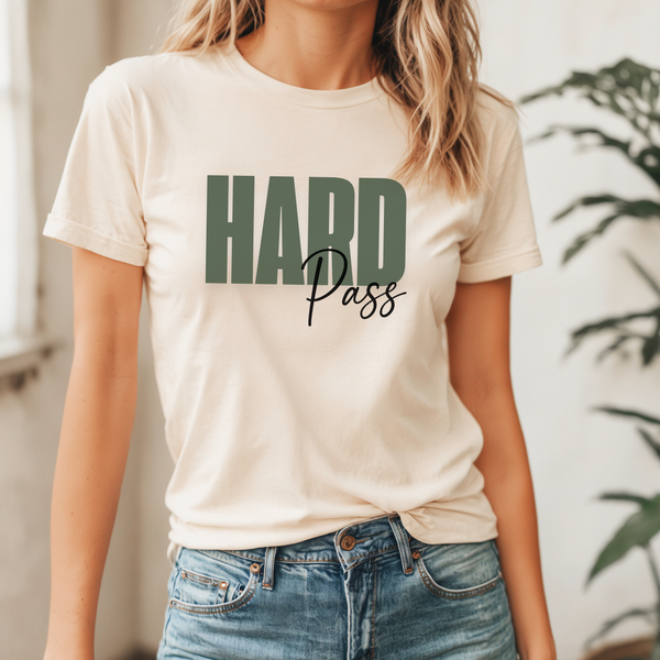 Person wearing a off white t-shirt with 'HARD Pass' text in green font in a casual setting