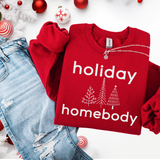 Red sweatshirt with 'holiday homebody' text and Christmas-themed decorations on a white background