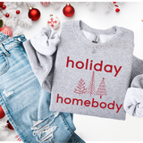 Gray sweatshirt with 'holiday homebody' text and Christmas tree designs on a festive background.