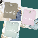 A photo array of three t-shirts - khaki, light pink, and light green that say
