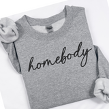 Gray sweatshirt with 'homebody' text on a white background