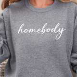 A woman in a graphite heather sweatshirt that says 