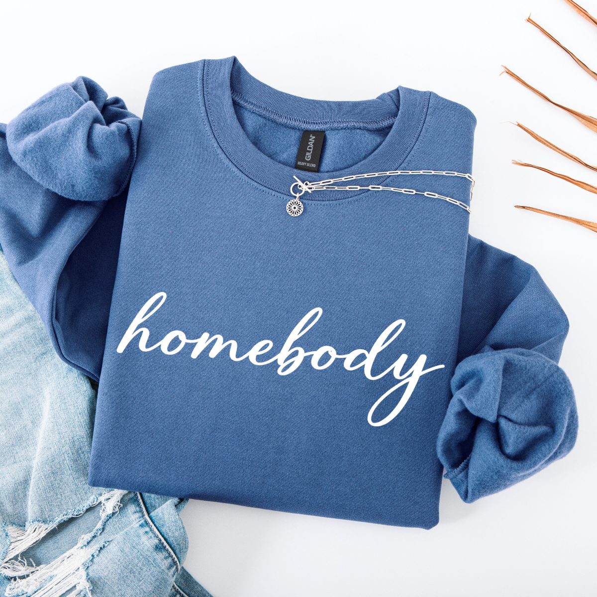 Blue sweatshirt with 'homebody' text on a white background