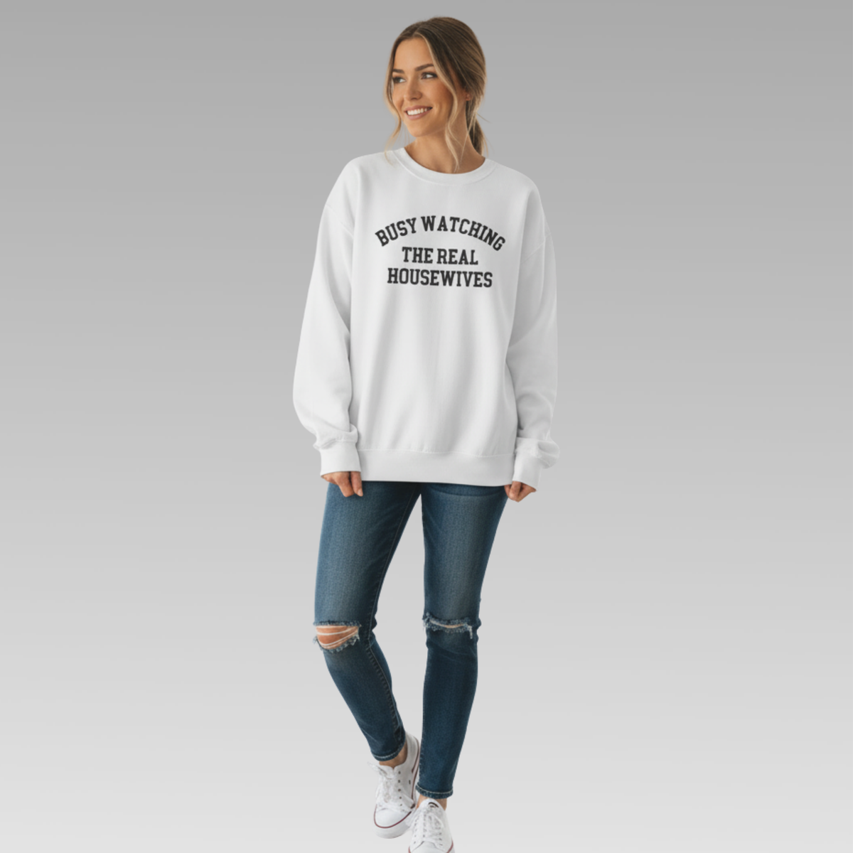 Woman wearing a white sweatshirt with text, standing against a plain background