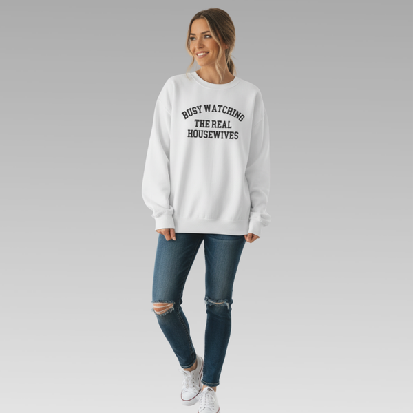Woman wearing a white sweatshirt with text, standing against a plain background