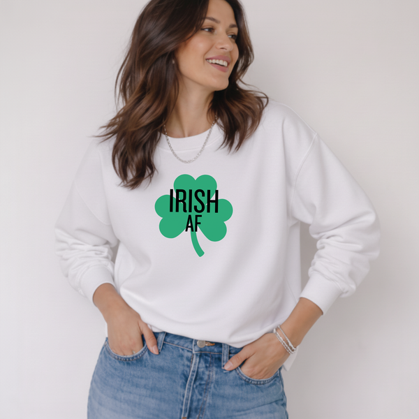 Woman wearing a white sweatshirt with 'IRISH AF' and a green clover design.