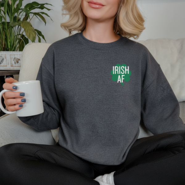 Woman wearing a dark gray sweatshirt with 'IRISH AF' text, holding a white mug.