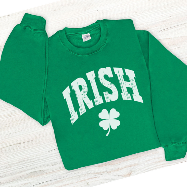 Green sweatshirt with 'IRISH' and a four-leaf clover on a white wooden surface