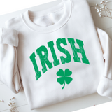 White sweatshirt with green 'IRISH' text and clover leaf on a light wooden surface.