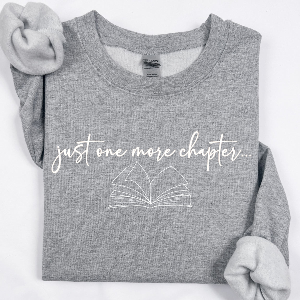 Gray t-shirt with 'just one more chapter...' text and book graphic on a white background