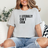 Person wearing a light gray t-shirt with 'I Literally Can't Even' text, sitting on a white couch.