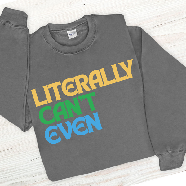 Gray sweatshirt with colorful text 'LITERALLY CAN'T EVEN' on a light wooden surface