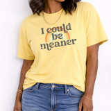 Person wearing a yellow t-shirt with a rainbow and text design against a white background