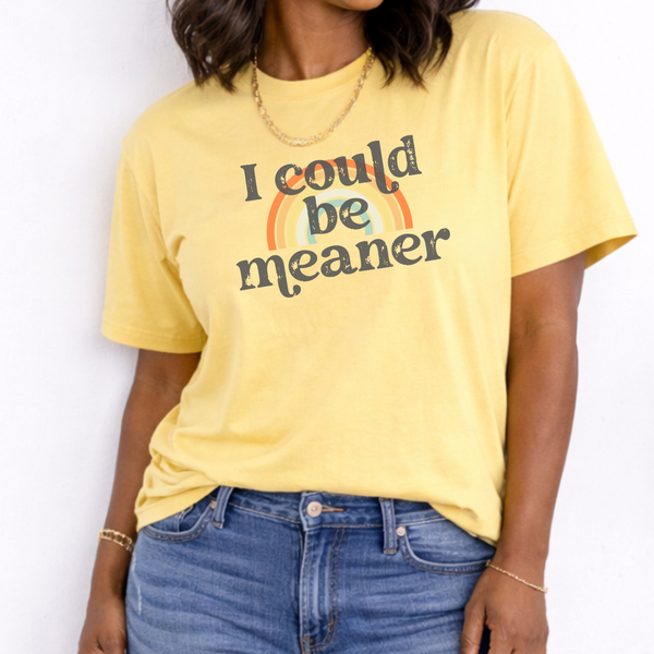 Person wearing a yellow t-shirt with a rainbow and text design against a white background