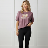 Woman wearing a berry pink purple t-shirt with a rainbow and text design, that says 