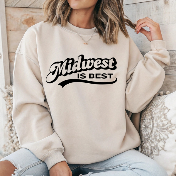 Person wearing a beige sweatshirt with 'Midwest is Best' text, sitting on a wooden floor.