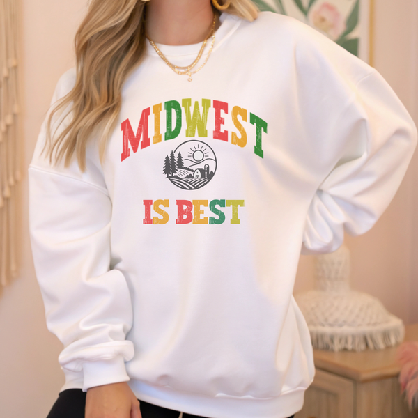 White sweatshirt with 'Midwest is Best' text in colorful letters worn by a person.
