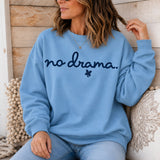 A woman in a light blue sweatshirt that says 