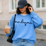 A woman in a light blue sweatshirt that says 