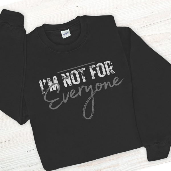 Black sweatshirt with 'I'm Not For Everyone' text on a white wooden surface