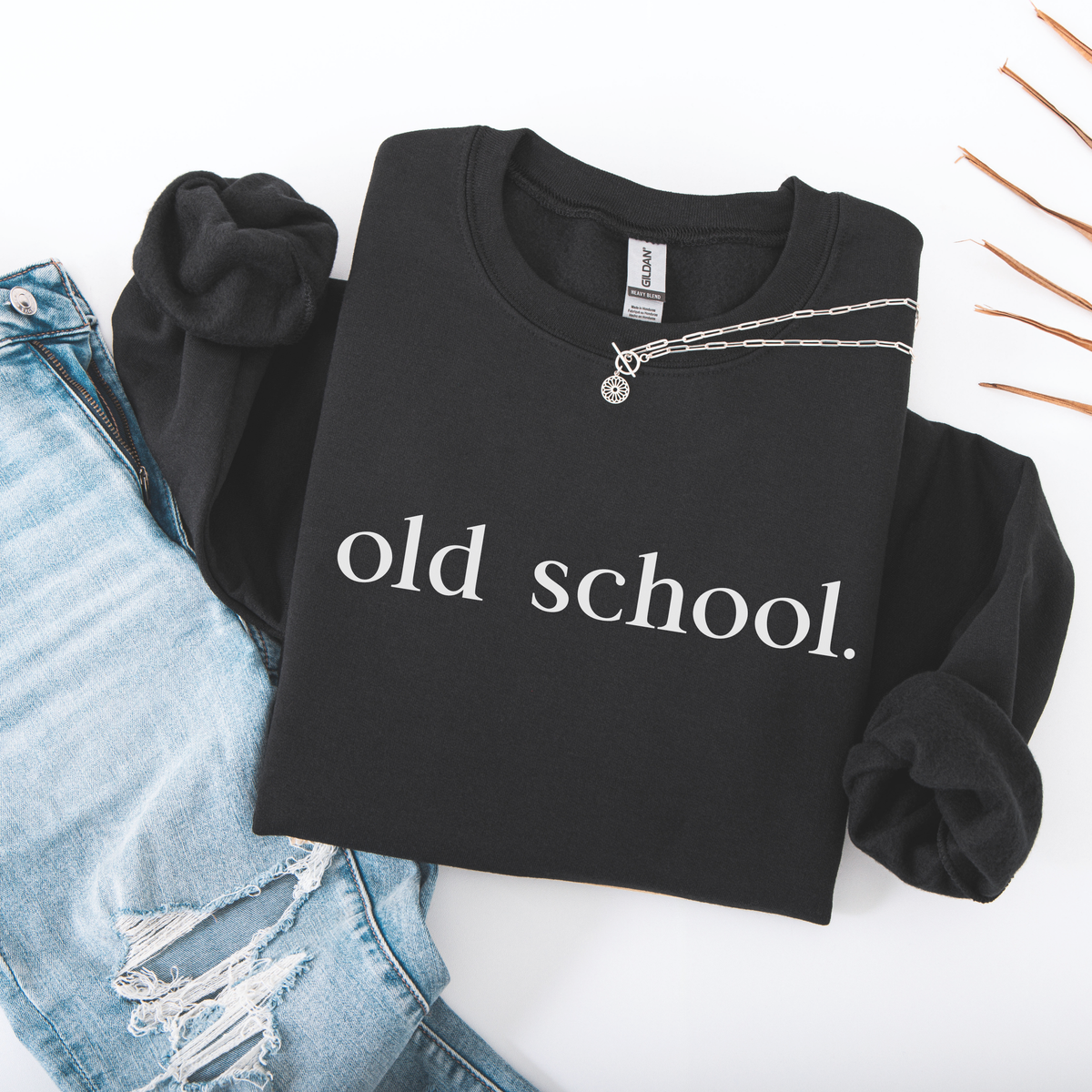 A folded Black sweatshirt with 'old school' text on a white background