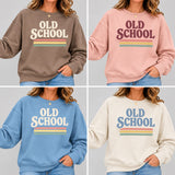 Four sweatshirt color options shown in a 2x2 grid, each worn by a model. The sweatshirts feature retro-style 'OLD SCHOOL' text with horizontal stripes in brown, pink, light blue, and cream.