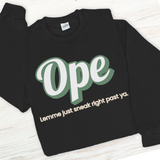 Black sweatshirt with green and white text on a wooden surface