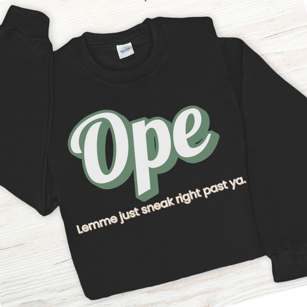 Black sweatshirt with green and white text on a wooden surface
