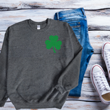 A dark light gray sweatshirt with a small pocket-sized shamrock on the top left of the sweatshirt.