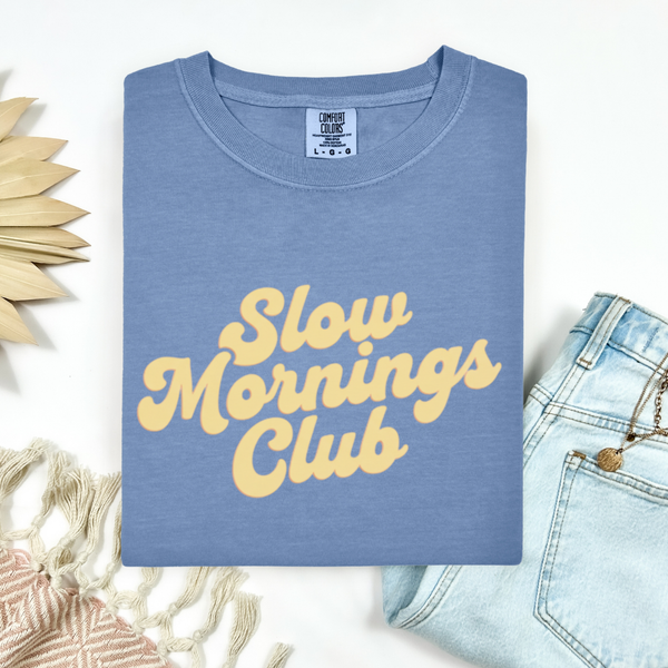 Blue t-shirt with 'Slow Mornings Club' text on a white background