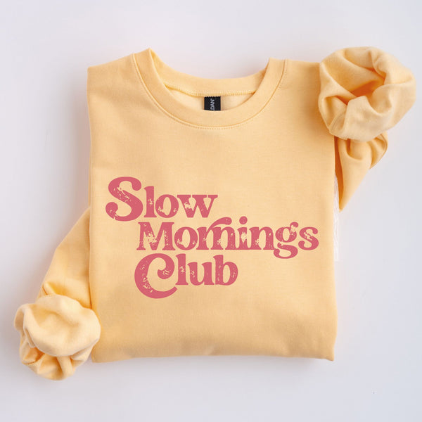 Yellow sweatshirt with 'Slow Mornings Club' pink text on a white background