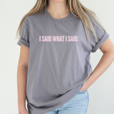 A female wearing a gray t-shirt with 'I SAID WHAT I SAID' text in pink on a plain background