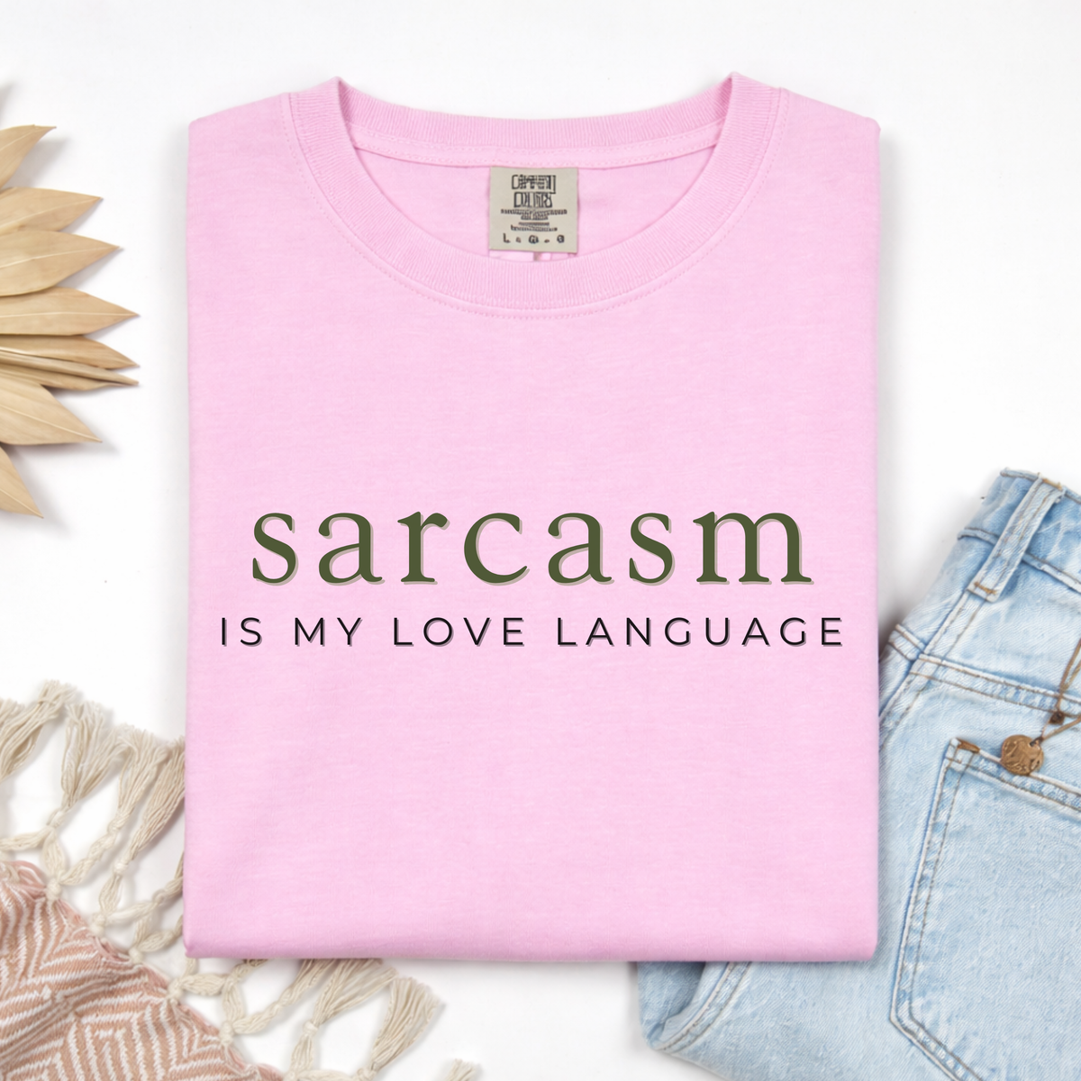 Pink t-shirt with 'sarcasm is my love language' text on a white background