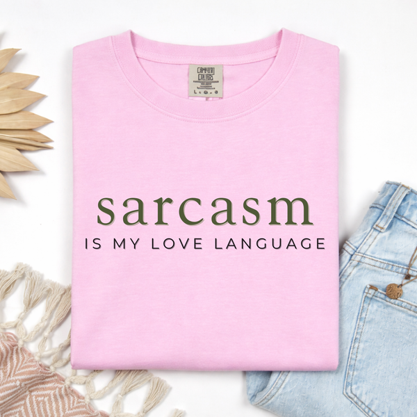 Pink t-shirt with 'sarcasm is my love language' text on a white background