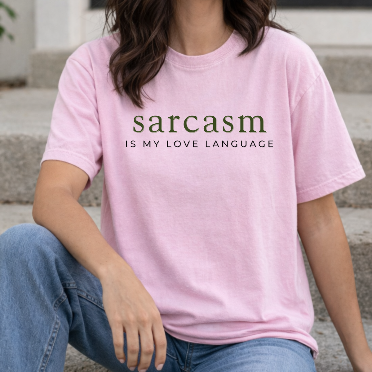 A woman wearing a pink t-shirt with 'sarcasm is my love language' text.