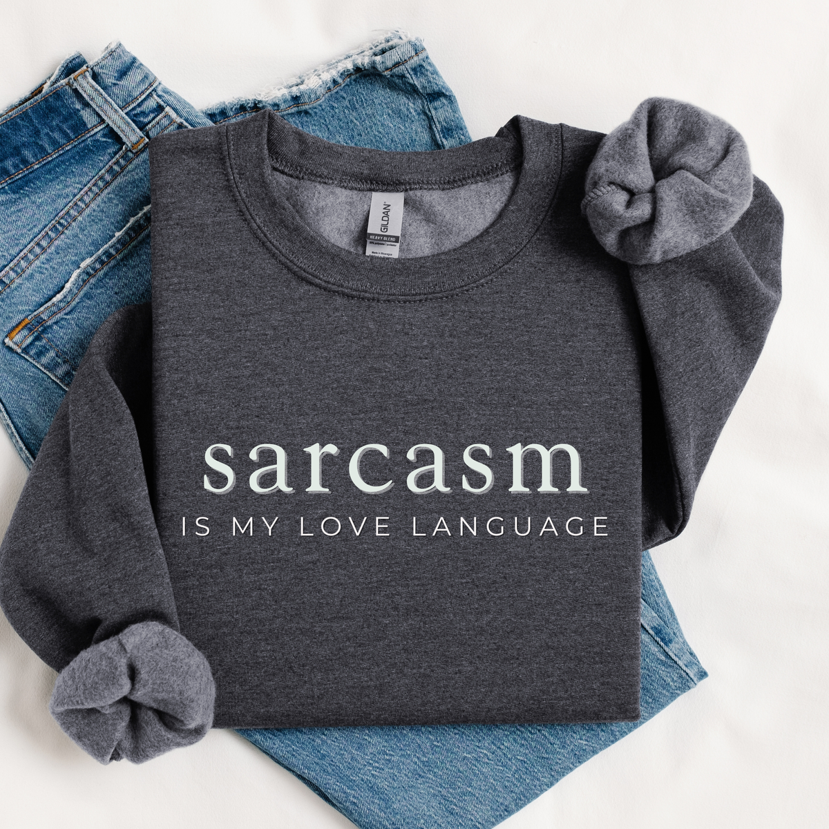 Gray sweatshirt with 'sarcasm is my love language' text on a white background