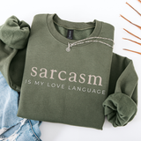 Green folded sweatshirt with 'sarcasm is my love language' text on a white background