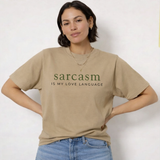 A woman wearing a khaki t-shirt with 'sarcasm is my love language' text on a white background