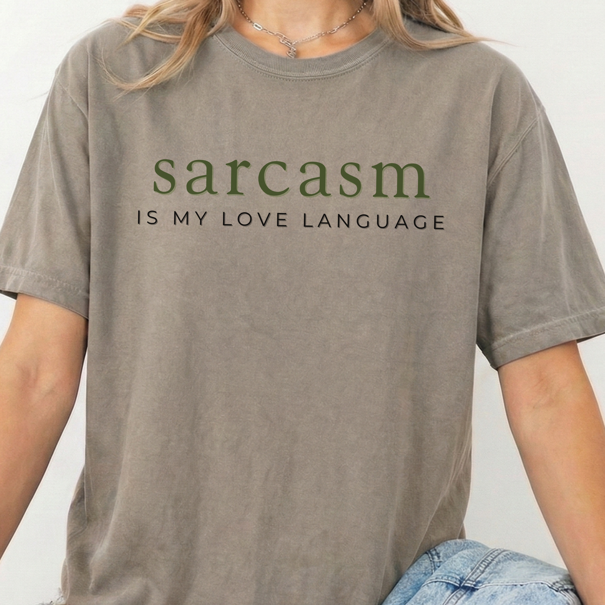 Person wearing a t-shirt with 'sarcasm is my love language' text on a plain background
