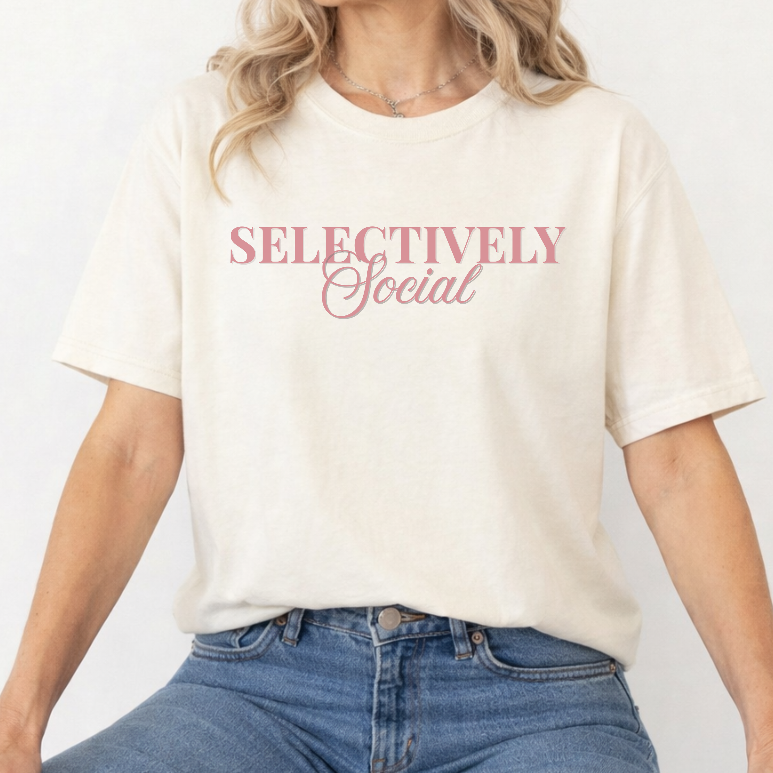 A woman wearing an ivory t-shirt with 'SELECTIVELY Social' text on a plain background