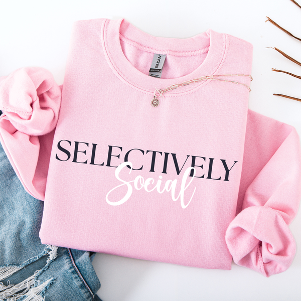 Pink sweatshirt with 'SELECTIVELY Social' text on a white background