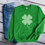 A green sweatshirt with a large lighter green shamrock in the middle.